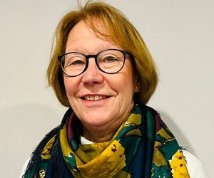 Sylvia Voit, stehend, leicht diagonal, nur Oberkörper, sie lächelt freundlich.