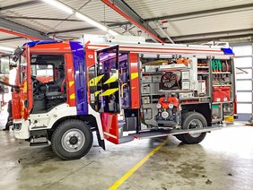 Löschfahrzeug LF10 in der Seitenansicht mit geöffneten Staufächern.