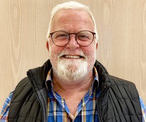 Portraitfoto von Andreas Patry, älterer Herr mit weißen Haaren und Bart, lächelnd, im Ratssaal.