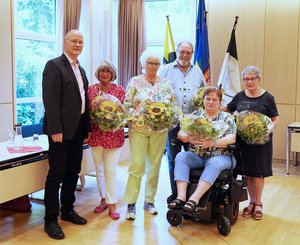 Die scheidenden Mitglieder der Seniorenvertretung mit dem Bürgermeister im Ratssaal, geehrt u.a. mit einem Blumenstrauß.