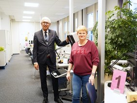 Bürgermeister Ralf Beßler und Monika Frauendorf aus den Bürgerservices stehen im Großraumbüro vor dem Passbildautomaten.