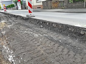 Abgefräste Fahrbahndecke mit darunterliegendem Pflasterstein.