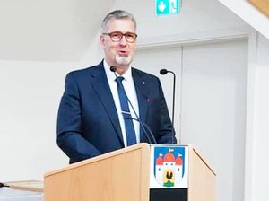 Schleusingens Bürgermeister hält eine Rede zu 35 Jahren Deutsche Einheit, hinter einem Pult stehend.