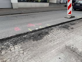 Abgefräste Fahrbahndecke mit darunterliegendem Pflasterstein.