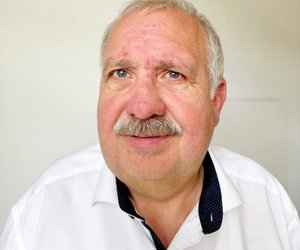 Portraitfoto von Dietmar Benner, lächelnd, weißes Hemd.