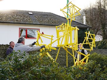 Das frisch restaurierte Kunstwerk DIASPORA wird auf dem jüdischen Friedhof Plettenberg mit einem Kran vorsichtig herabgelassen.