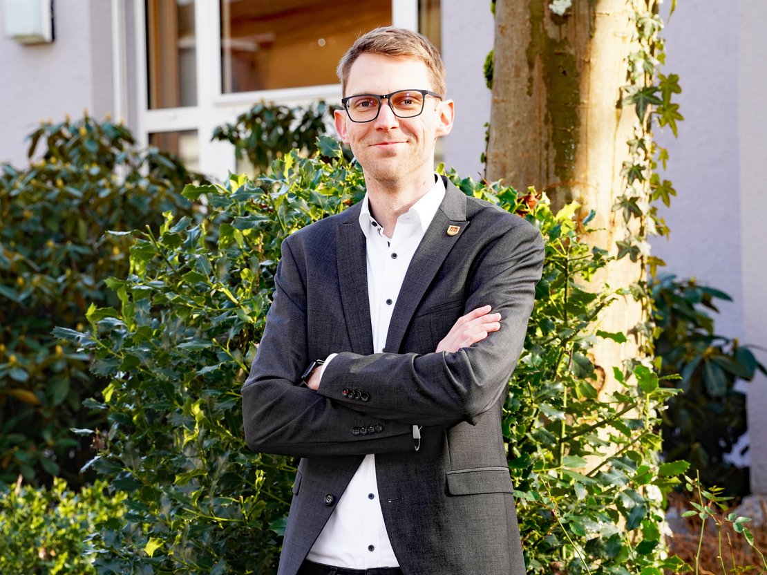 Kämmerer Jannim Brinkmann, lächelnd, die Arme lässig verschränkt.