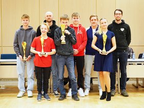 Die Gruppe geehrter Sportler:innen freut sich über die Urkunden und Pokale.