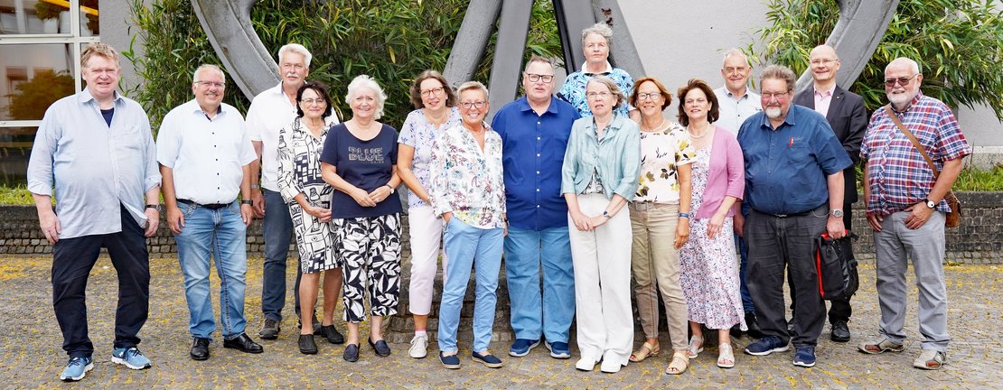 Gruppenbild der 2025 frisch gewählten Seniorenvertretung Plettenberg, vor dem Schwungrad im Rathausinnenhof.