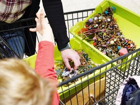 Kinder schmücken einen Weihnachtsbaum im Supermarkt.