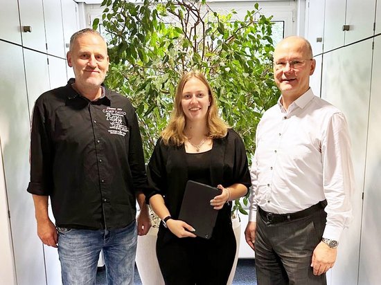 Die neue Auszubildende des Jahres 2025, Laura Cappelletti, zwischen Matthias Steinhoff und Bürgermeister Ulrich Schulte. Flur des Rathaus-Vorzimmers, große grüne Pflanze im Hintergrund.
