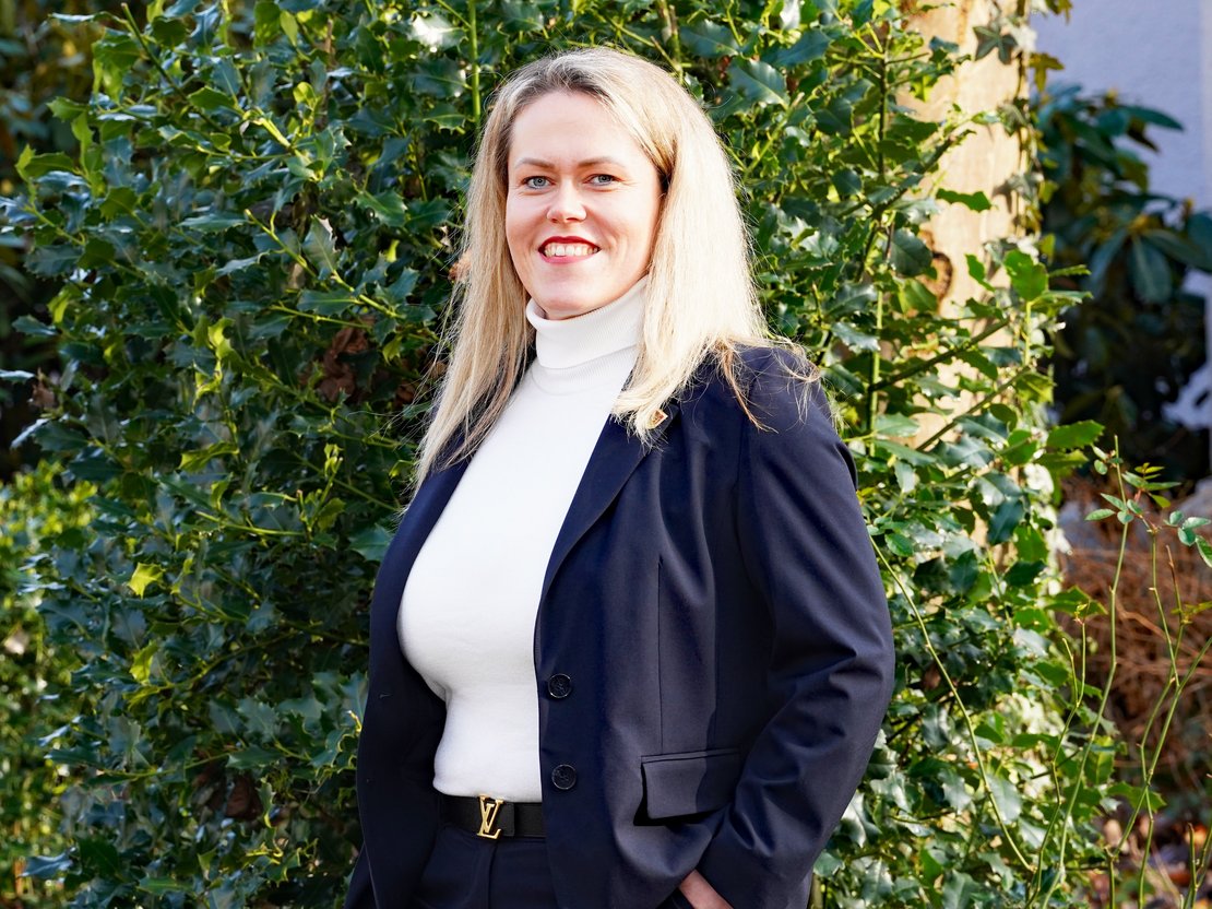 Fachgebietsleiterin Soziales, Sabrina C. Müller, lächelnd, die Hände lässig in den Hosentaschen.