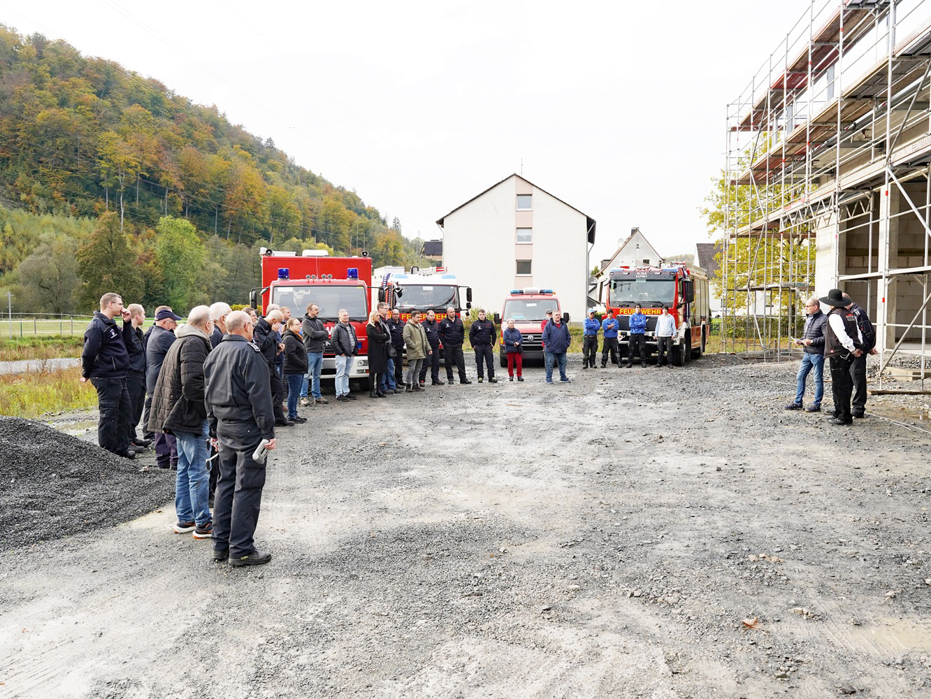 Die Gäste und Redner sind vor dem Rohbau versammelt.